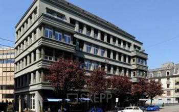 Modern office space rental at Bleicherweg 10 in the lively Zürich Enge district, featuring a well-maintained exterior with large windows and a street-side café.